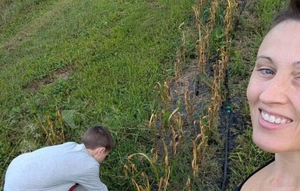 Mom and son with rows of garlic