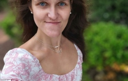 Photo of a young woman outside smiling at the camera.