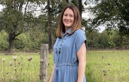 Portrait headshot in foreground with rural scenic background