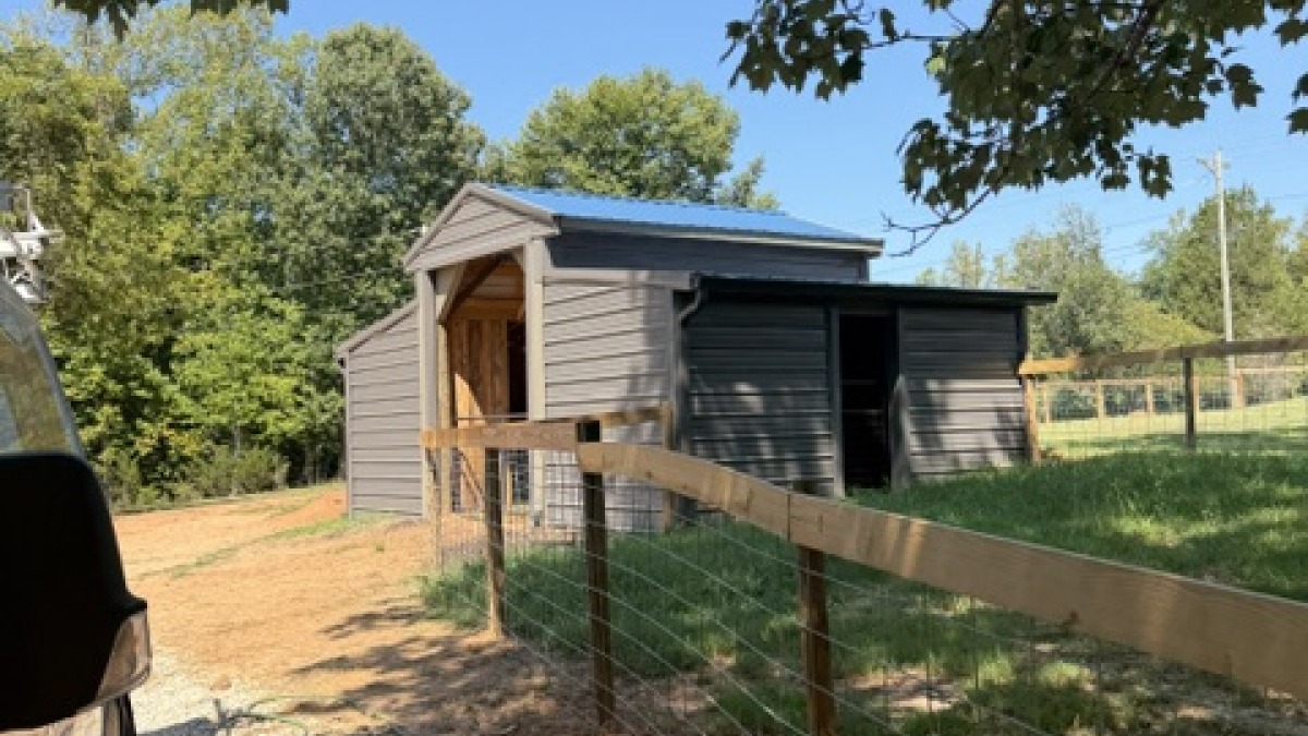 the new barn with 2 large stalls, and 4 small stalls.  side door leads into a smaller fenced area.  main door leads to the large fenced lot