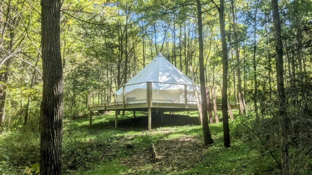 Glamping tent on raised platform in walnut grove