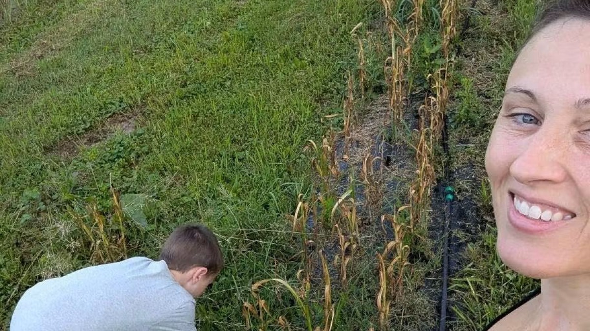 Mom and son with rows of garlic