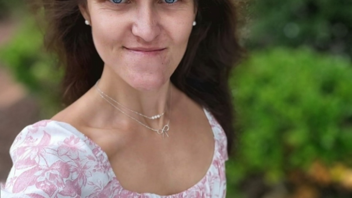 Photo of a young woman outside smiling at the camera.