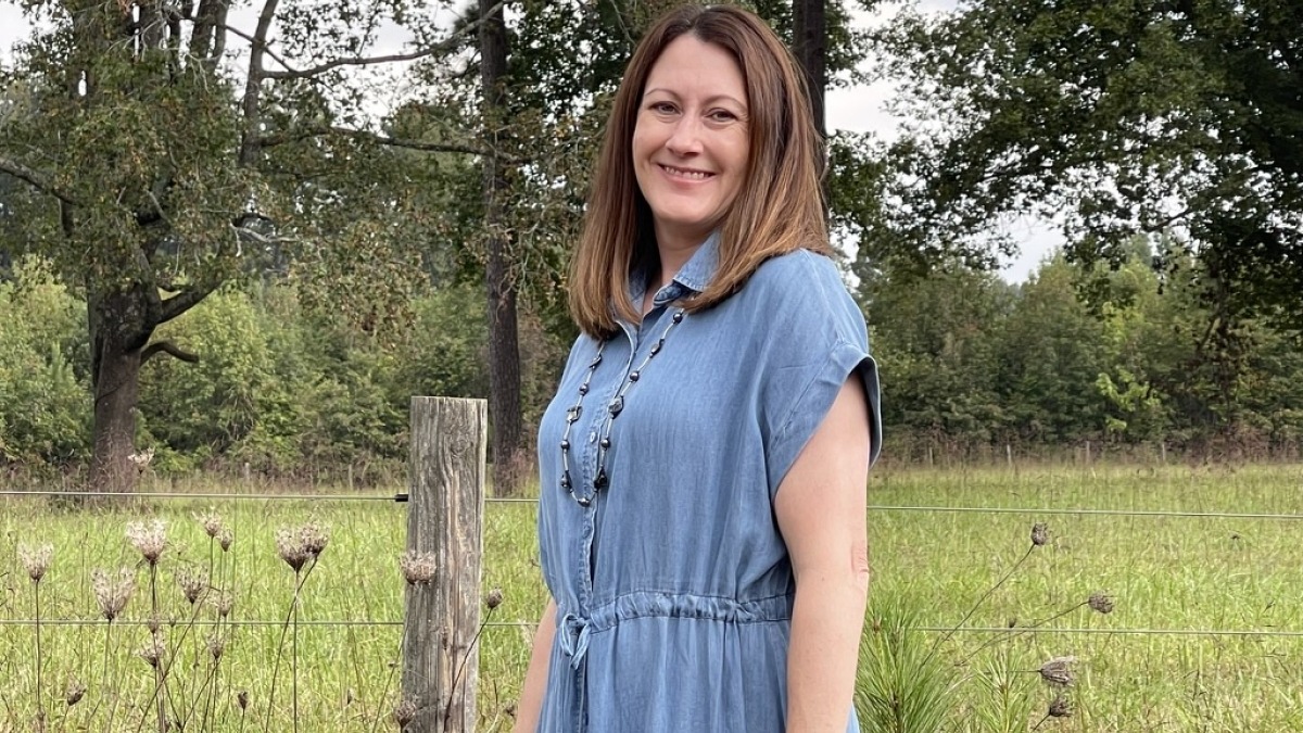 Portrait headshot in foreground with rural scenic background