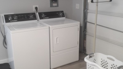 Airbnb utility room with water and dryer