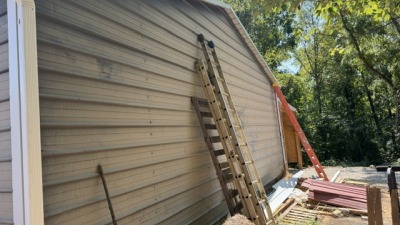 back side of large building.  this side faces the farm area.  the other side has 2 large roll up doors.  on the side is a large open and covered bay