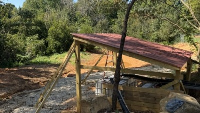water retention containers, roofed, with new pond in background