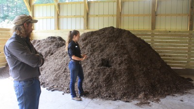 Kimber standing next to a compost pile at Biltmore