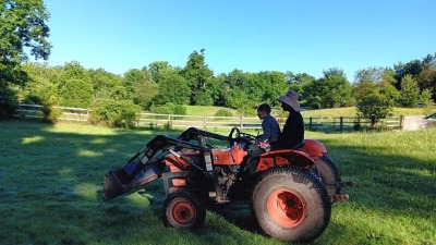 Mom and son driving tractor down to garlic fields 