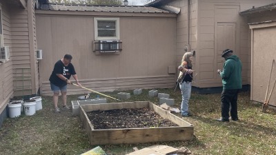 Community Members working and hanging out in our small community garden