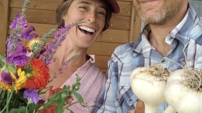 Mike and Shelly with bouquets of flowers and fresh garlic