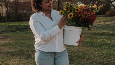 in a field with a bucket of flowers