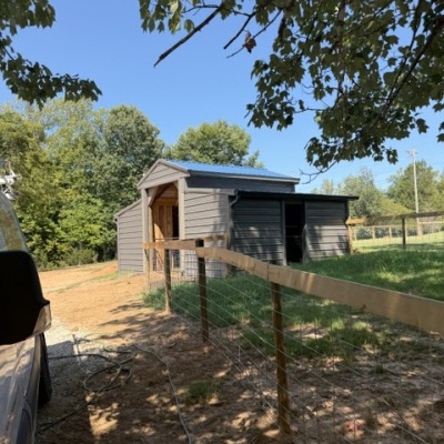 the new barn with 2 large stalls, and 4 small stalls.  side door leads into a smaller fenced area.  main door leads to the large fenced lot