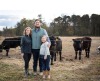 Family standing with cattle herd