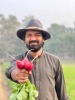 Arzish Azam holding organic veggies